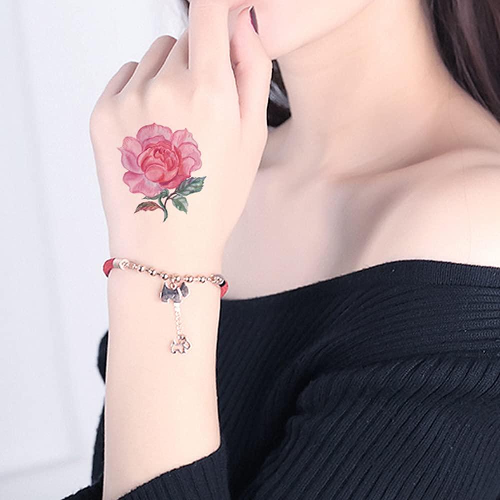 Red peony tattoo on the right upper arm.